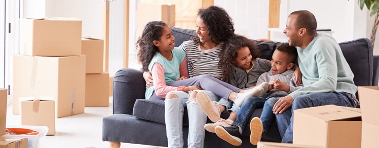 Smiling family sitting on the couch in new home
